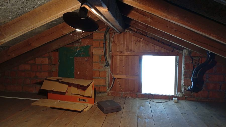 Dachgeschoss vor dem Umbau: alter Dachstuhl, gemauerter Kamin, Dielenboden, ein Dachfenster