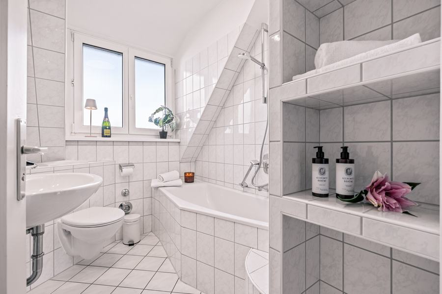 Bad im Dachgeschoss mit Wanne und Fenster in der Dachschräge