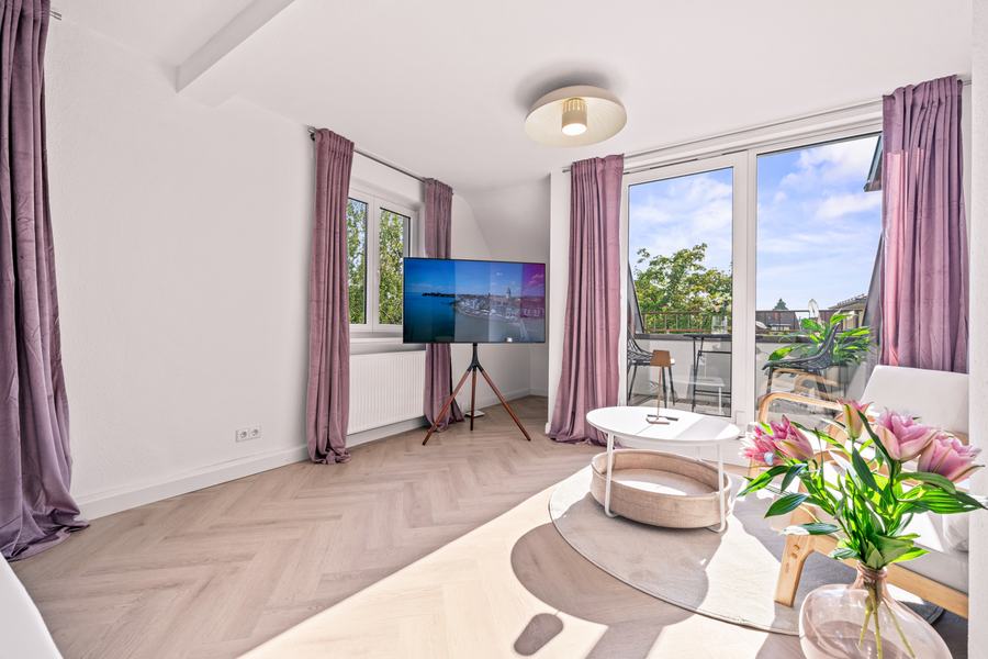 Wohnraum der Dachgeschosswohnung mit Dachschrägen und Holzboden