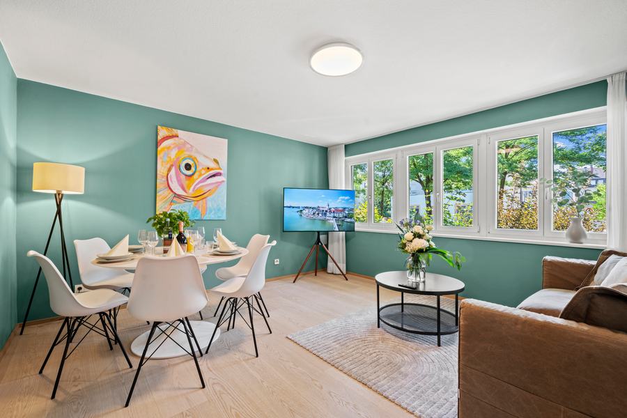 Wohnraum im Erdgeschoss mit grüner Wand, Esstisch und Sofa