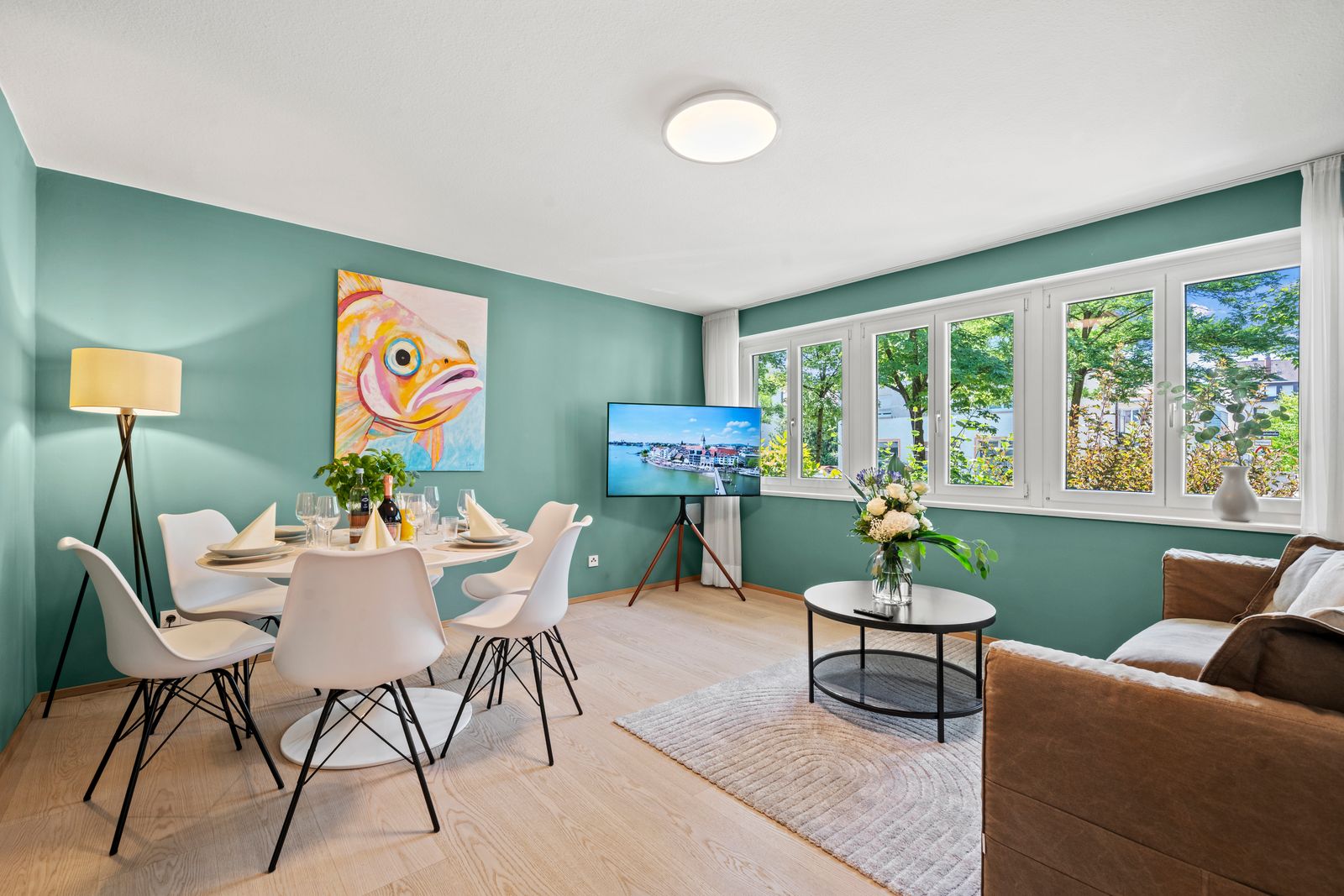 Wohnraum im Erdgeschoss der Riedleparkstraße 36 mit grüner Wand, Esstisch und Sofa